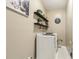 Laundry room with washer, dryer, decorative shelves, and neutral walls at 1424 Brighton, Loganville, GA 30052