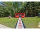 View of the red outbuilding in yard, featuring walkway and swing at 1424 Brighton, Loganville, GA 30052
