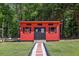 Red outbuilding featuring black shutters, Route 66 decor and manicured walkway at 1424 Brighton, Loganville, GA 30052
