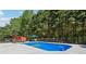 Outdoor swimming pool with diving board, pool toys and shaded patio area at 1424 Brighton, Loganville, GA 30052