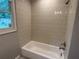 Neutral bathroom featuring a tub/shower with tile surround, shower head, and window at 1909 Cindy Dr, Decatur, GA 30032