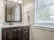 Bright bathroom featuring framed mirror, wooden vanity with drawers, and natural light at 2055 Summer View Place Sw, Marietta, GA 30060