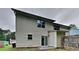 View of the back of a two-story house with sliding glass doors and a fenced yard with some grass at 5634 Windwood Rd, Atlanta, GA 30349