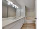 Bathroom featuring a large white vanity, bright lighting, large mirror and shower-tub combination at 5634 Windwood Rd, Atlanta, GA 30349