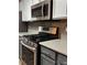 Upgraded stainless steel gas range oven and microwave nestled between shaker cabinets and stylish backsplash at 851 Walkingstick Dr, Douglasville, GA 30134