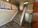 Carpeted staircase with wooden handrail, connecting floors with neutral wall paint and wood-look flooring at 851 Walkingstick Dr, Douglasville, GA 30134