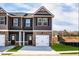 New construction townhome features neutral paint, brick accents, and attached garage at 231 Ivey Ter, Temple, GA 30179