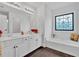 Bright bathroom with double vanity, soaking tub, and decorative window at 2586 Abbotts Glen Nw Dr, Acworth, GA 30101