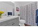 Well-lit bathroom with gray vanity, patterned shower curtain, and modern fixtures at 2586 Abbotts Glen Nw Dr, Acworth, GA 30101