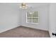 Bright bedroom featuring neutral carpet, a modern ceiling fan, and a window at 2586 Abbotts Glen Nw Dr, Acworth, GA 30101