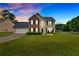 Charming two-story home with brick and vinyl siding, a manicured lawn, and an attached two-car garage at 2586 Abbotts Glen Nw Dr, Acworth, GA 30101
