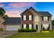 A beautifully lit two-story home featuring a brick and siding exterior, complemented by a well-kept lawn and a two-car garage at 2586 Abbotts Glen Nw Dr, Acworth, GA 30101