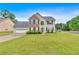 Inviting two-story home with brick and vinyl siding, black shutters, an attached garage, and a green lawn at 2586 Abbotts Glen Nw Dr, Acworth, GA 30101