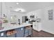 Modern kitchen with white cabinetry, stainless steel appliances, island with bar stools, and hardwood floors at 2586 Abbotts Glen Nw Dr, Acworth, GA 30101