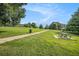 A well maintained community area with a grassy field, picnic table, and playground under a beautiful blue sky at 4445 Vanadium Bend, Cumming, GA 30040