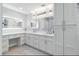 Bright bathroom with dual sinks, white cabinetry, and a large, lighted mirror at 9058 Woodlake Lane, Villa Rica, GA 30180