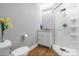 Well-lit bathroom with a toilet, vanity, and a glass enclosed shower with a handheld shower head at 9058 Woodlake Lane, Villa Rica, GA 30180