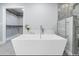 Modern bathroom featuring a freestanding tub, glass-enclosed shower with dual shower heads, and heated towel rack at 9058 Woodlake Lane, Villa Rica, GA 30180