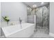 Modern bathroom featuring a freestanding tub, glass-enclosed shower with dual shower heads, and heated towel rack at 9058 Woodlake Lane, Villa Rica, GA 30180