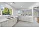Modern kitchen with white cabinets, stainless steel appliances, and a large window offering scenic backyard views at 9058 Woodlake Lane, Villa Rica, GA 30180