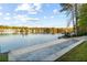 Serene lake view with a private beach area and dock, offering a tranquil setting for relaxation and water activities at 9058 Woodlake Lane, Villa Rica, GA 30180