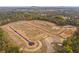 Aerial view reveals the site surrounded by trees, fall foliage, and hills on the horizon at 155 Pickens Bluff Ln, Hiram, GA 30141