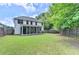 A spacious backyard enclosed by a wooden fence featuring a screened-in porch and lush green grass at 2020 Walking Horse Trl, Cumming, GA 30041