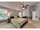 Light-filled primary bedroom with ceiling fan, windows, and access to en-suite bathroom at 2020 Walking Horse Trl, Cumming, GA 30041