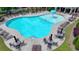 An aerial view of the community pool featuring tables, chairs, umbrellas, and easy access steps to enter at 2020 Walking Horse Trl, Cumming, GA 30041