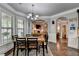 Elegant dining room with stylish chandelier, hardwood floors, and large windows offering ample natural light at 2020 Walking Horse Trl, Cumming, GA 30041