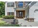 Inviting home entrance with a cozy bench, brick accents, and meticulous landscaping at 2020 Walking Horse Trl, Cumming, GA 30041