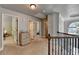 Upstairs hallway featuring neutral carpet, black iron railing, and multiple doors at 2020 Walking Horse Trl, Cumming, GA 30041