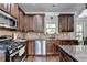 Modern kitchen featuring stainless appliances, dark cabinets, granite counters, and hardwood floors at 2020 Walking Horse Trl, Cumming, GA 30041