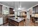 Spacious kitchen featuring dark cabinets, stainless appliances, granite counters, and breakfast bar at 2020 Walking Horse Trl, Cumming, GA 30041