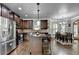 Open-concept kitchen featuring dark cabinets, stainless appliances, and breakfast bar at 2020 Walking Horse Trl, Cumming, GA 30041