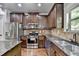 Updated kitchen with stainless steel appliances, dark wood cabinets, and stone countertops at 2020 Walking Horse Trl, Cumming, GA 30041