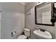 Cozy powder room with pedestal sink, framed mirror, and toilet at 2020 Walking Horse Trl, Cumming, GA 30041