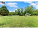 Expansive backyard with mature trees and a charming outbuilding, creating a serene outdoor space at 2620 Dr Bramblett Rd, Cumming, GA 30028