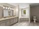 Bright bathroom featuring tiled floors, double sinks, a soaking tub and a window with natural light at 2620 Dr Bramblett Rd, Cumming, GA 30028