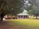 Charming brick home featuring a metal roof, manicured landscaping, and a welcoming front porch at 2620 Dr Bramblett Rd, Cumming, GA 30028