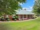 Beautiful brick home with a metal roof and covered front porch enhanced by professional landscaping at 2620 Dr Bramblett Rd, Cumming, GA 30028