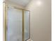Shower featuring glass doors, gold trim and neutral walls at 2620 Dr Bramblett Rd, Cumming, GA 30028