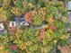 Aerial view of the home surrounded by a canopy of beautiful trees in full autumn colors at 2775 Hogan Rd, Atlanta, GA 30344