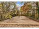 View of the backyard featuring mature trees, an empty sports court area, and chain link fence at 2775 Hogan Rd, Atlanta, GA 30344