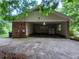 Large open carport features brick supports, storage, and access to the backyard at 3026 Hidden Forest Dr, Snellville, GA 30078