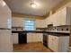 Well-lit kitchen with white cabinets, black appliances, and vinyl flooring at 3026 Hidden Forest Dr, Snellville, GA 30078