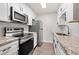 Modern kitchen with stainless steel appliances, granite countertops, white cabinetry, and subway tile backsplash at 3304 Pine Heights Ne Dr, Atlanta, GA 30324