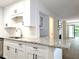 Bright kitchen featuring white cabinets, granite countertops, and a view to the living room at 3304 Pine Heights Ne Dr, Atlanta, GA 30324