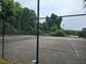 Community tennis court surrounded by lush trees and secure fencing at 3304 Pine Heights Ne Dr, Atlanta, GA 30324