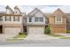 Charming townhome featuring a two-car garage, stone accents, and manicured landscaping at 2243 Knoxhill Se Vw, Smyrna, GA 30082